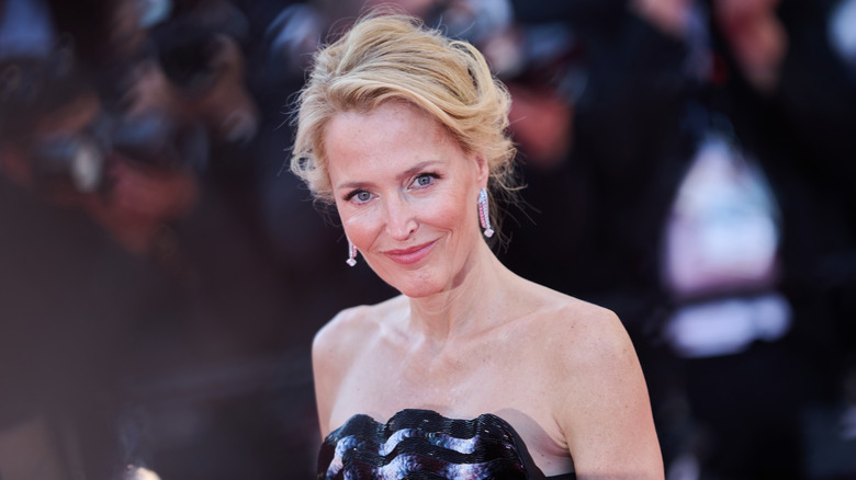 Gillian Anderson smiles wearing a black-and-white strapless dress