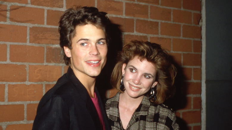 Young Rob Lowe and Melissa Gilbert in front of a brick wall
