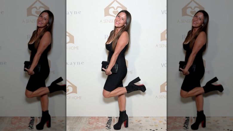 Soleil Moon Frye posing with her foot kicked up wearing a black dress with black platform boots,