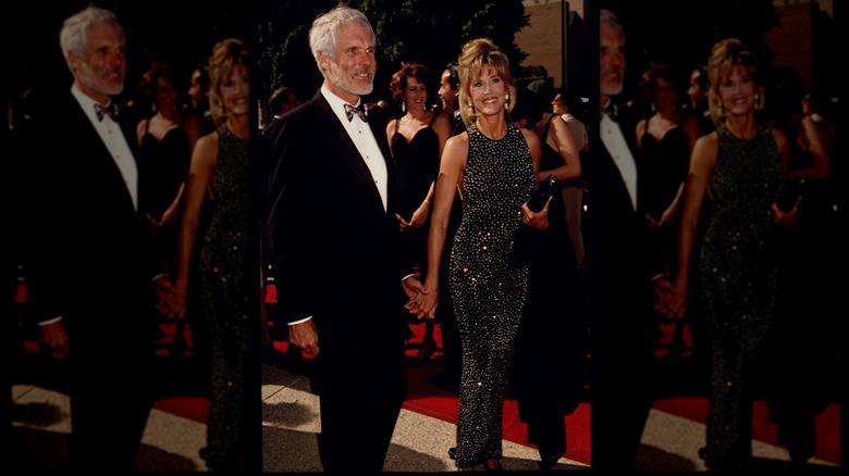 Jane Fonda on the red carpet at the Emmy Awards wearing a long, bejeweled black dress with a halter neck.