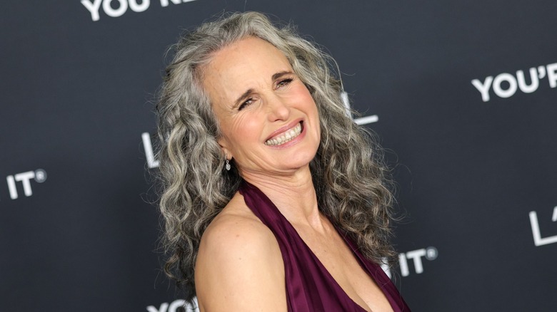 Andie MacDowell wore her curly gray hair down with a maroon halter-neck dress at the 20th Anniversary of L'Oreal Paris Women of Worth event in Los Angeles in 2025.