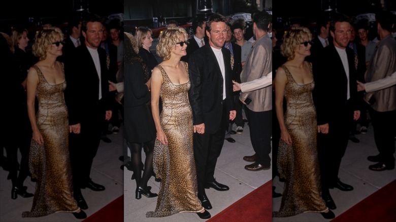 Meg Ryan in a gold dress with sunglasses posing with Dennis Quaid in a suit at a red carpet event.