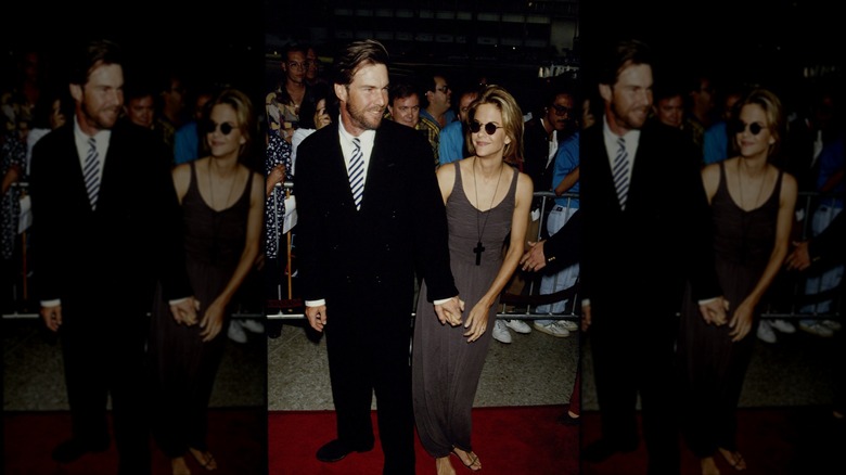 Dennis Quaid poses with Meg Ryan who is wearing a gray dress and sunglasses.