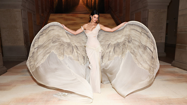 Kendall Jenner poses wearing a nude gown with statement bat sleeves