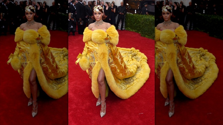 Rihanna poses wearing a fur trim mustard gown