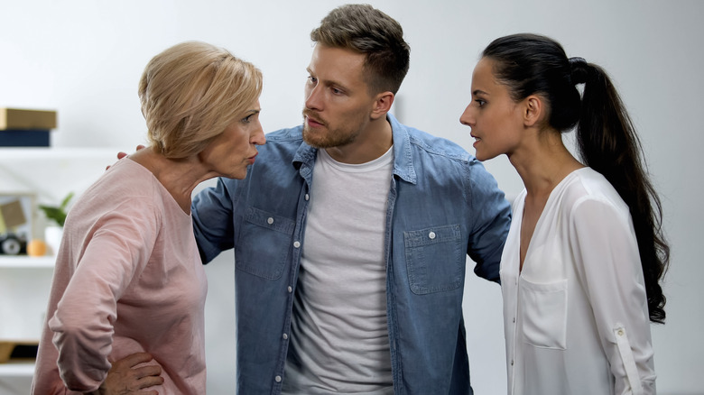 Young couple in heated dispute with older woman