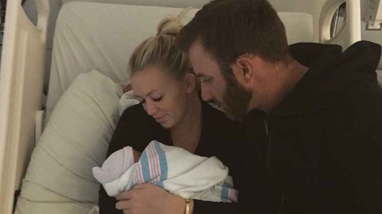 Dustin Johnson cuddles Paulina Gretzky as she holds their newborn son, Tatum Johnson in the hospital.