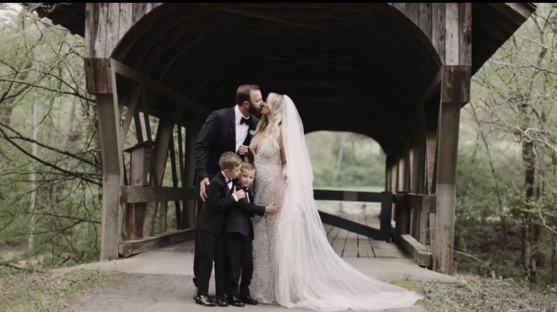 Dustin Johnson kisses Paulina Gretzky as their two children, Tatum and River Johnson, hug them on their wedding day.