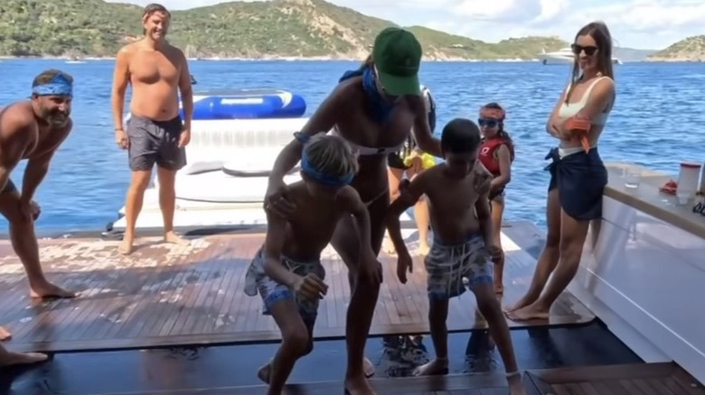 Family looking on as Paulina Gretzky plays with her sons, Tatum and River Johnson, on a boat.