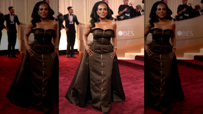 Sheryl Lee Ralph smiling on the red carpet wearing a chocolate-brown strapless dress with a cape.