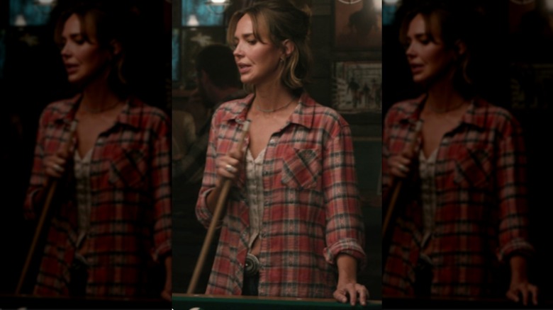 Belle Skinner wearing a red plaid shirt with a beige top and jeans