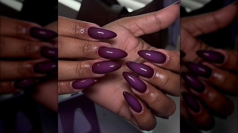 An almond manicure with a purple nail polish