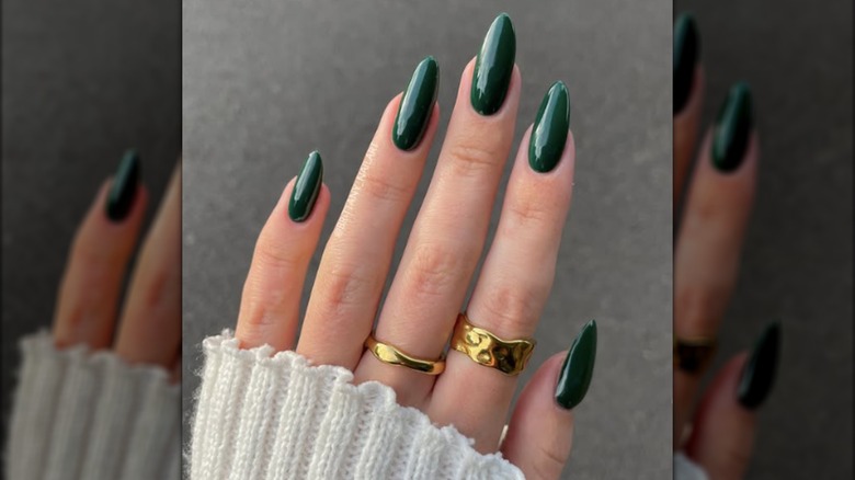 A long round manicure with dark forest green nail polish