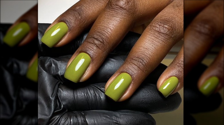 A short manicure with olive green nail polish