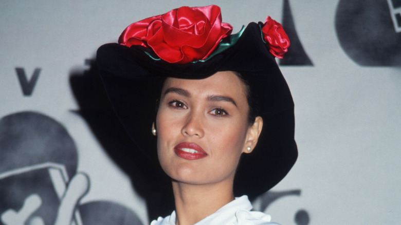 Tia Carrere wearing a floppy hat with silk roses and a white top at the 1992 MTV Movie Awards.