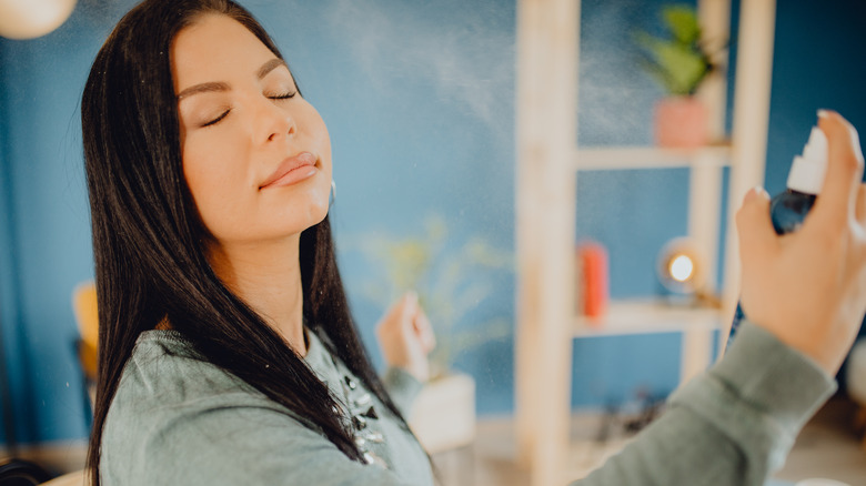 A woman applying setting spray
