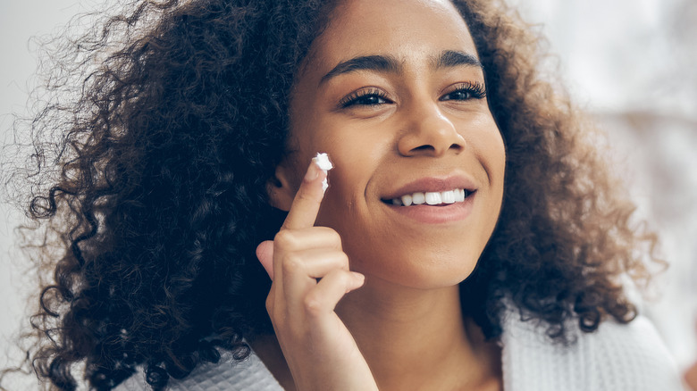 Woman applying moisturizer