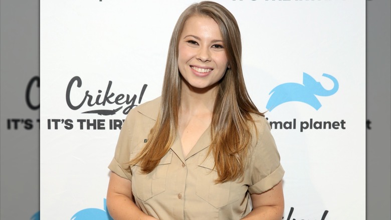 Bindi Irwin posing on a red carpet in khaki with her hair down
