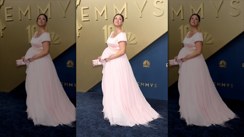 Kaley Cuoco smiles wearing a pink cutout gown with a baby bump