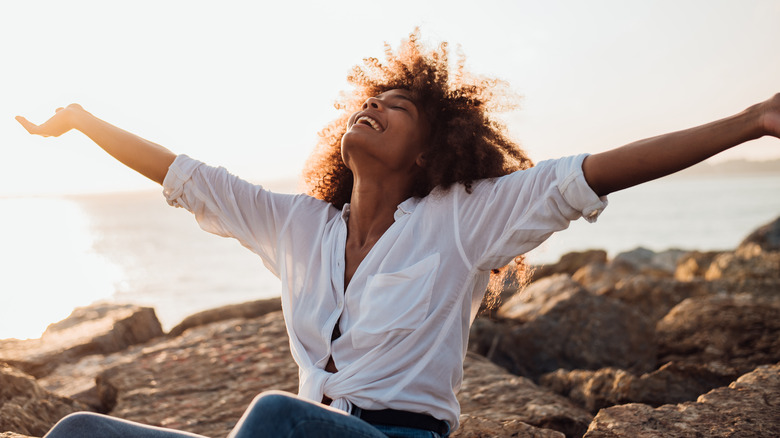 free woman holds her arms up