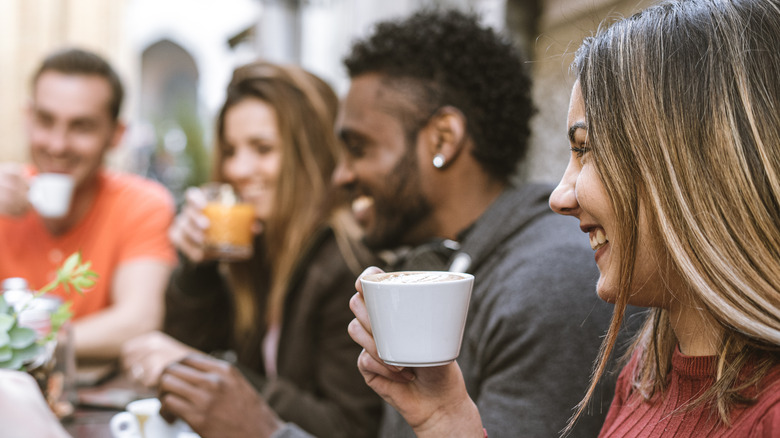 Woman drinking coffee with friends