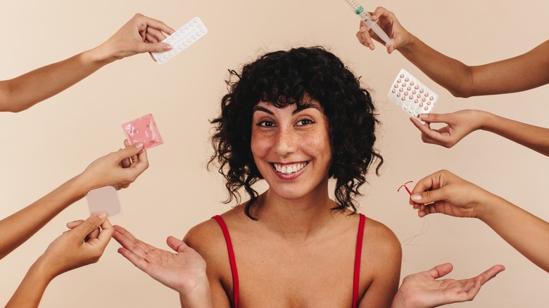 woman surrounded by contraceptive options