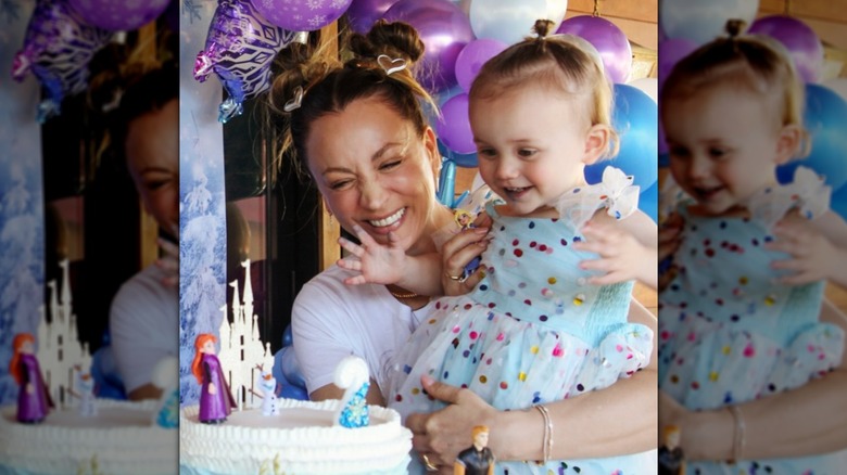 Kaley Cuoco beams with joy while holding up daughter Matilda to blow out her birthday cake during a festive "Frozen"-themed party.