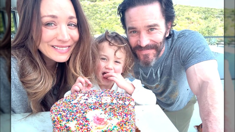 Kaley Cuoco and Tom Pelphrey pose with daughter Matilda while eating a gender reveal cake.