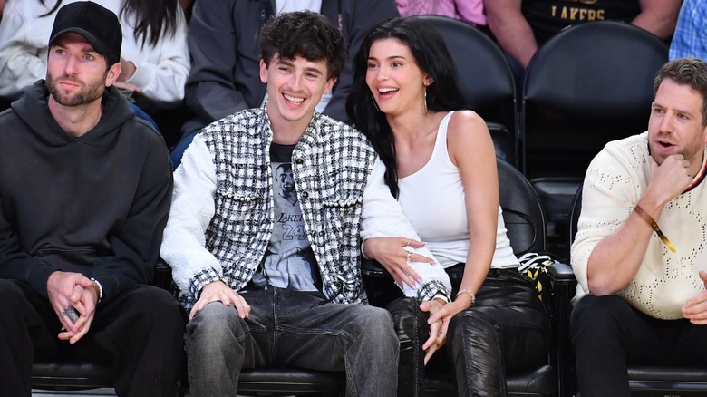 Timothée Chalamet and Kylie Jenner laughing in the crowd of a sports event