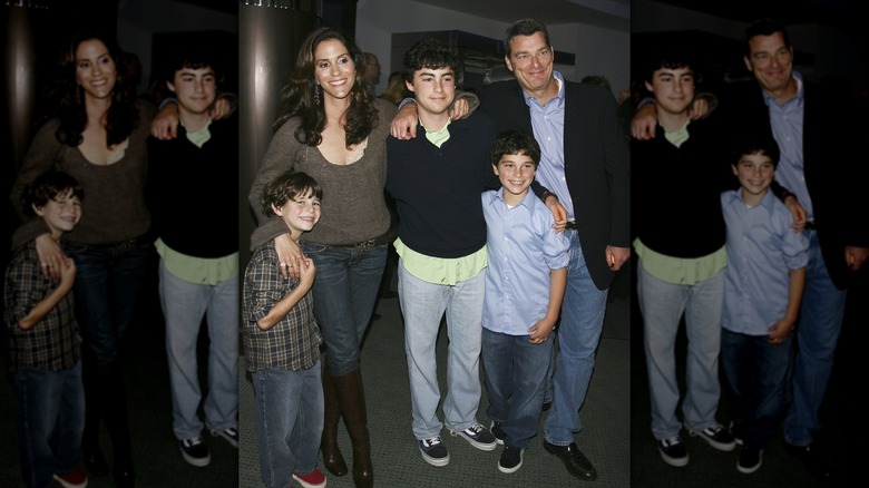 Jami Gertz and Tony Ressler posing with their three sons