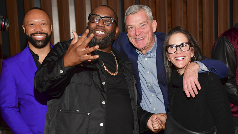 Jami Gertz and Tony Ressler posing with Killer Mike and Paul Judge