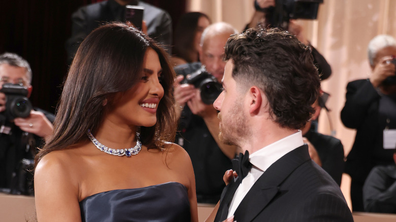 Priyanka Chopra and Nick Jonas look at each other while on the 2026 Golden Globes red carpet