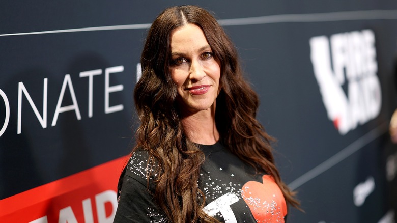 Alanis Morissette wearing a black top on the red carpet.