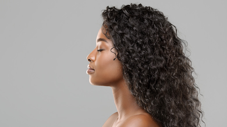 Model with long curly hair and peaceful expression