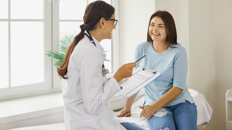 Woman happily chats with doctor