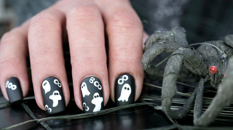 ghosts painted on black nail polish