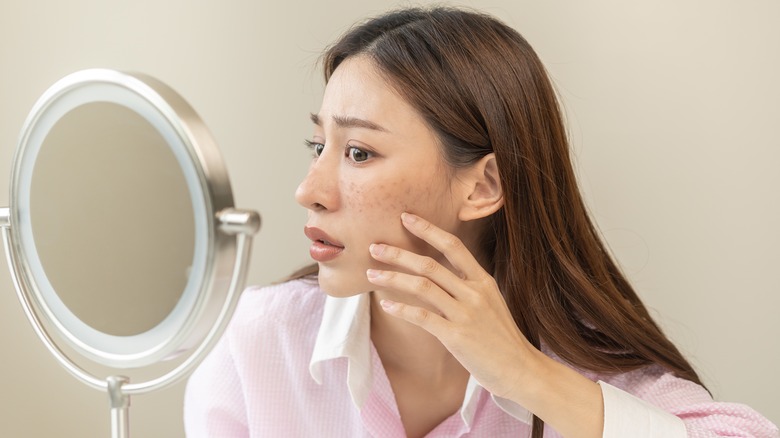 Girl viewing skin in mirror