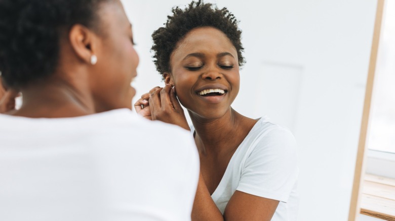 Woman putting on earrings