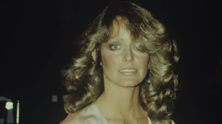 A photograph of Farrah Fawcett shows her with big curled hair that is partially covering her face