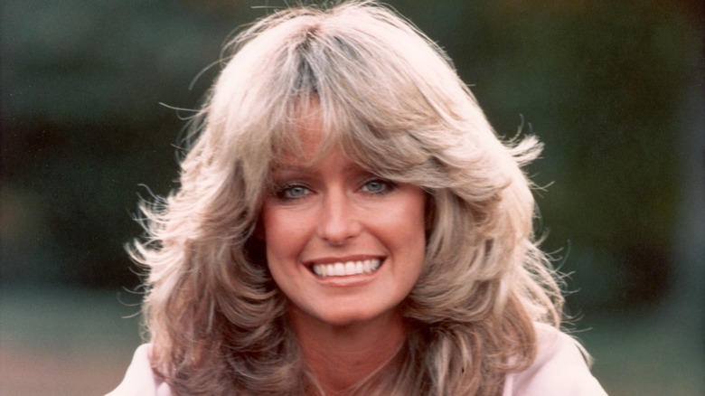 Actor Farrah Fawcett is pictured smiling in front of a blurred green background