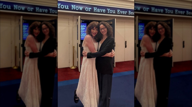 Molly Ringwald wearing a white dress and Ally Sheedy wearing a black outfit hugging and posing for a photo in 2026.