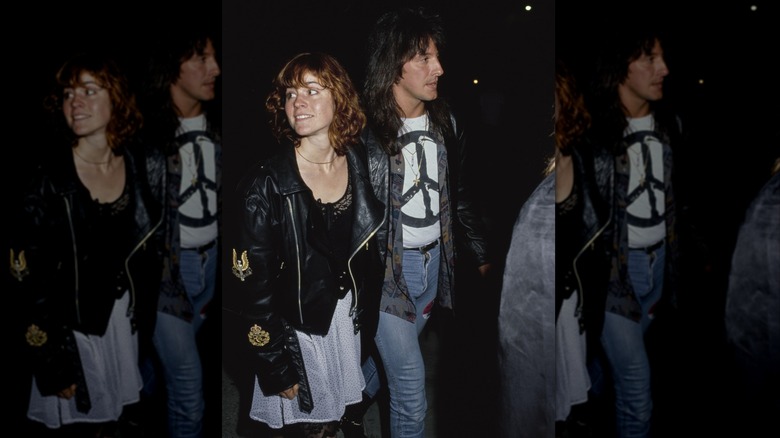 Ally Sheedy wearing a black top with a white skirt and black leather jacket walking with boyfriend Richie Sambora wearing jeans, a peace sign t-shirt, and black jacket.
