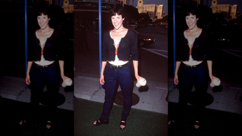 Ally Sheedy in 1998 wearing dark-blue jeans with a white top and black cardigan.