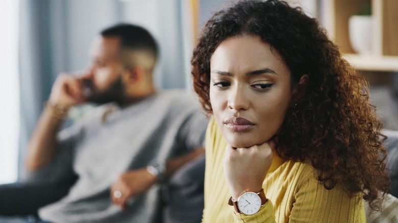 Unhappy couple sitting on couch