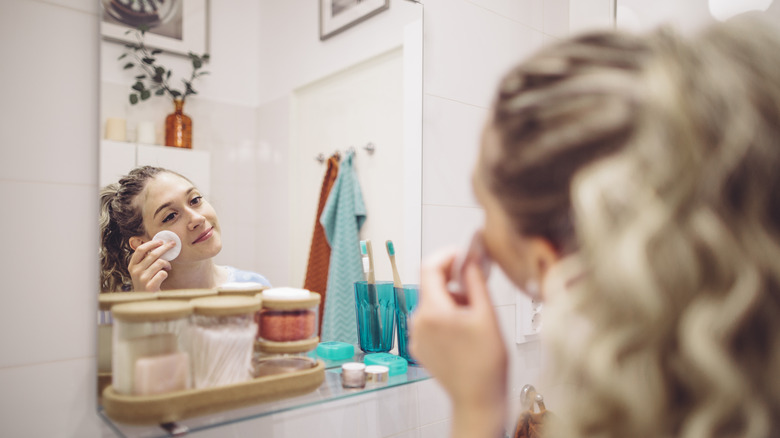 woman doing skincare routine in bathroom