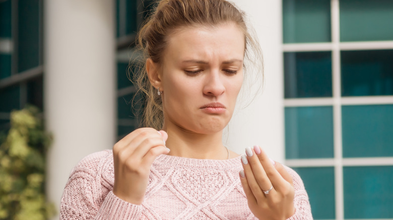 worried woman looking at nails