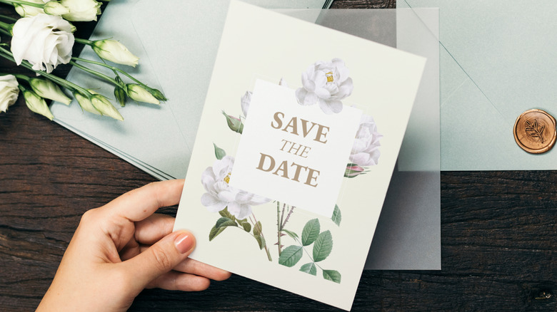 person holding wedding invitation