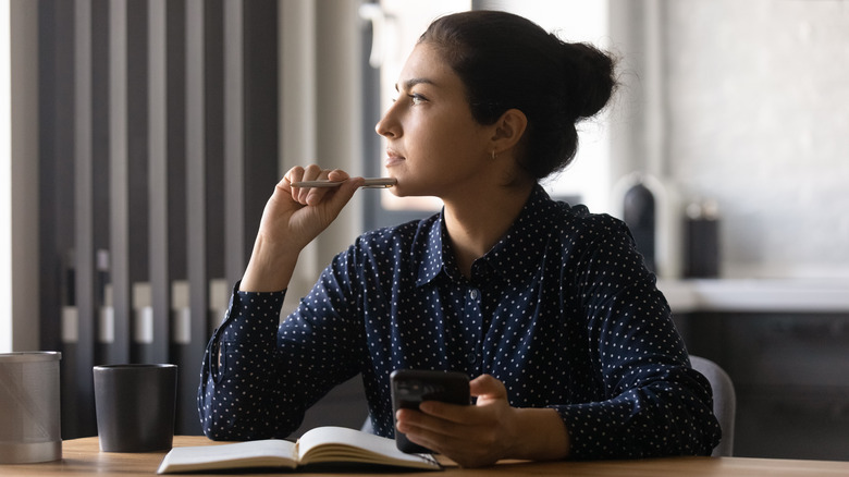 Woman with phone and notebook