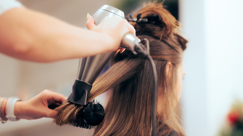 Stylist giving a hair blowout.