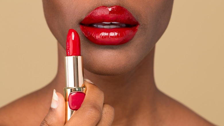 woman applying red lipstick